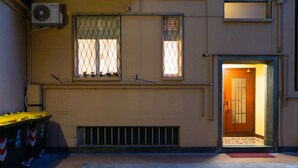 A building with two windows, a door, and a trash bin. - [AC, Centralissimo] Bertola by HappyHosTorino (Torino)