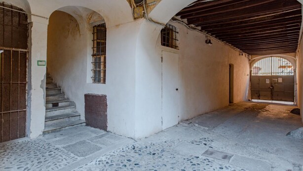 An interior with a staircase, arched doorways, and a tiled floor. - Casa M&M] Luminosa: Borgo Dora (Torino)