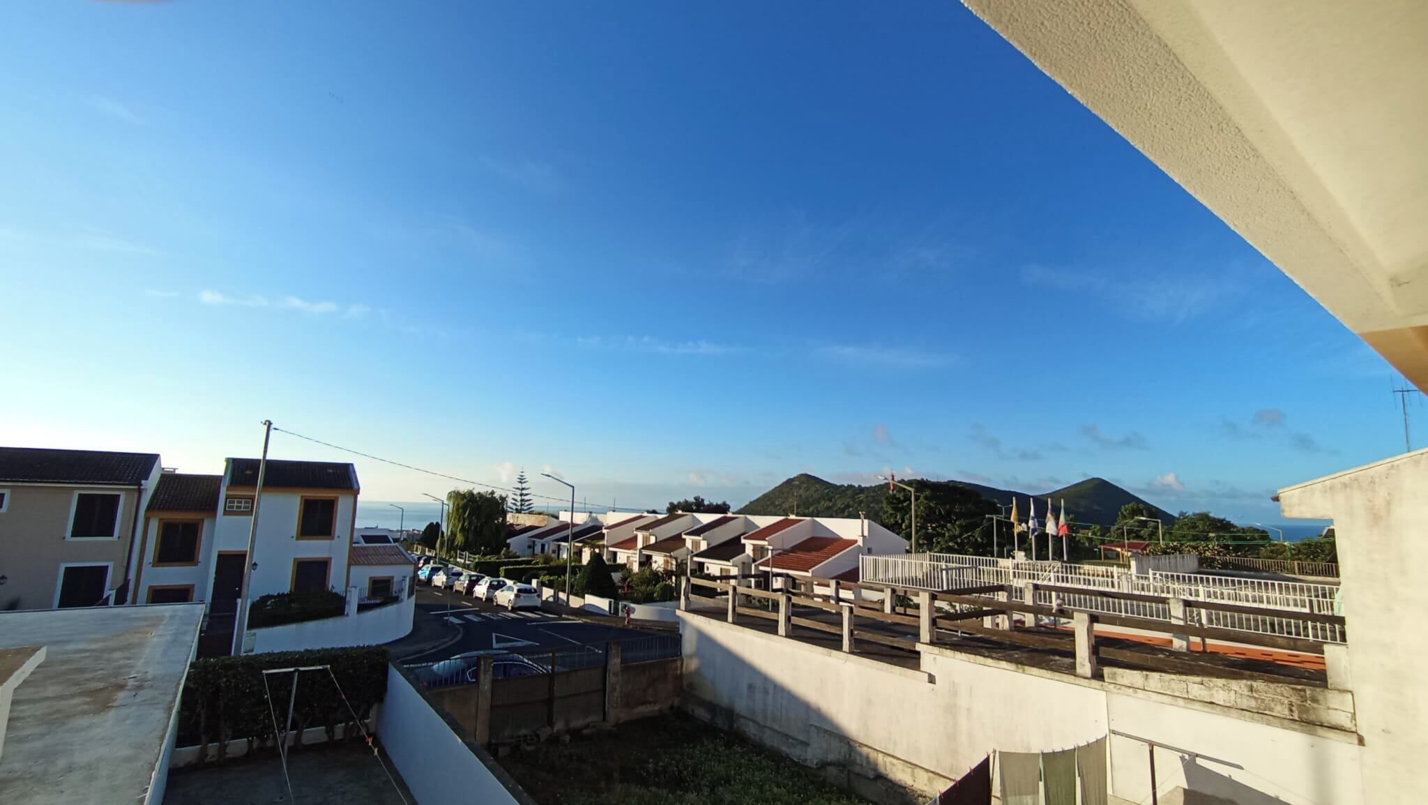 Zona residencial con varias casas, un puente y una montaña al fondo.
