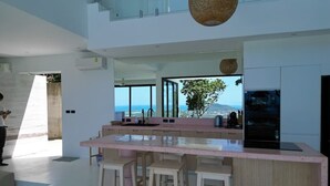 A modern kitchen with a large island, bar stools, and a view of the ocean. - Palmaya Villa - Piscine & Vue mer - 3 chambres (Ko Samui)