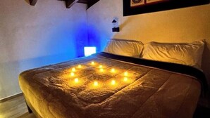 Una cama con colcha y guirnalda de luces formando un diseño cuadrado sobre el edredón.
