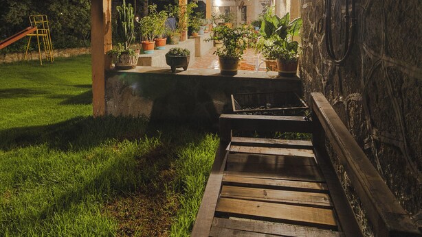Un bâtiment en pierre doté d’une terrasse en bois qui mène à un patio abrité.