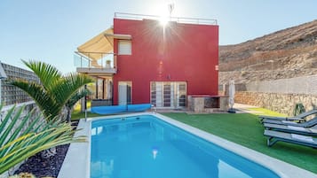 Una piscina al aire libre, tumbonas