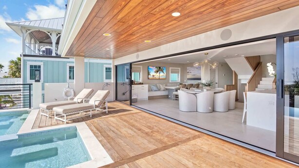 A modern house with a pool, outdoor seating, and a large glass door leading to a living area. - Siesta Beachfront Paradise - Infinity Pool & Spa! (Sarasota)