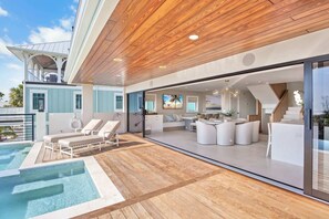 A modern house with a pool, outdoor seating, and a large glass door leading to a living area. - Siesta Beachfront Paradise - Infinity Pool & Spa! (Sarasota)