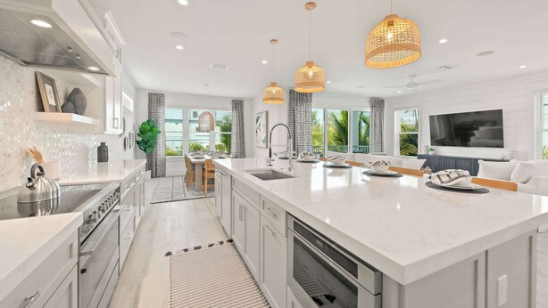 A modern kitchen with a large island, stainless steel appliances, and pendant lighting. - Beach View Paradise - New Anna Maria Island Home (Bradenton Beach)