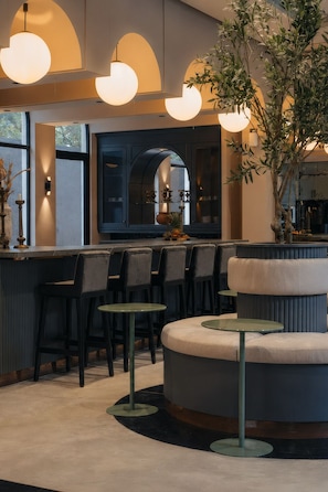 Ein modernes Interieur mit Barbereich, Sitzgelegenheiten und einer großen Pflanze.