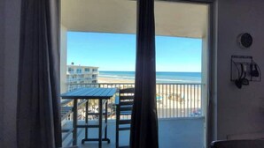 A balcony with a view of the beach and ocean. - Cozy Ocean Front Getaway ~ Sleeps 2 ~ Pools Open! (Daytona Beach)