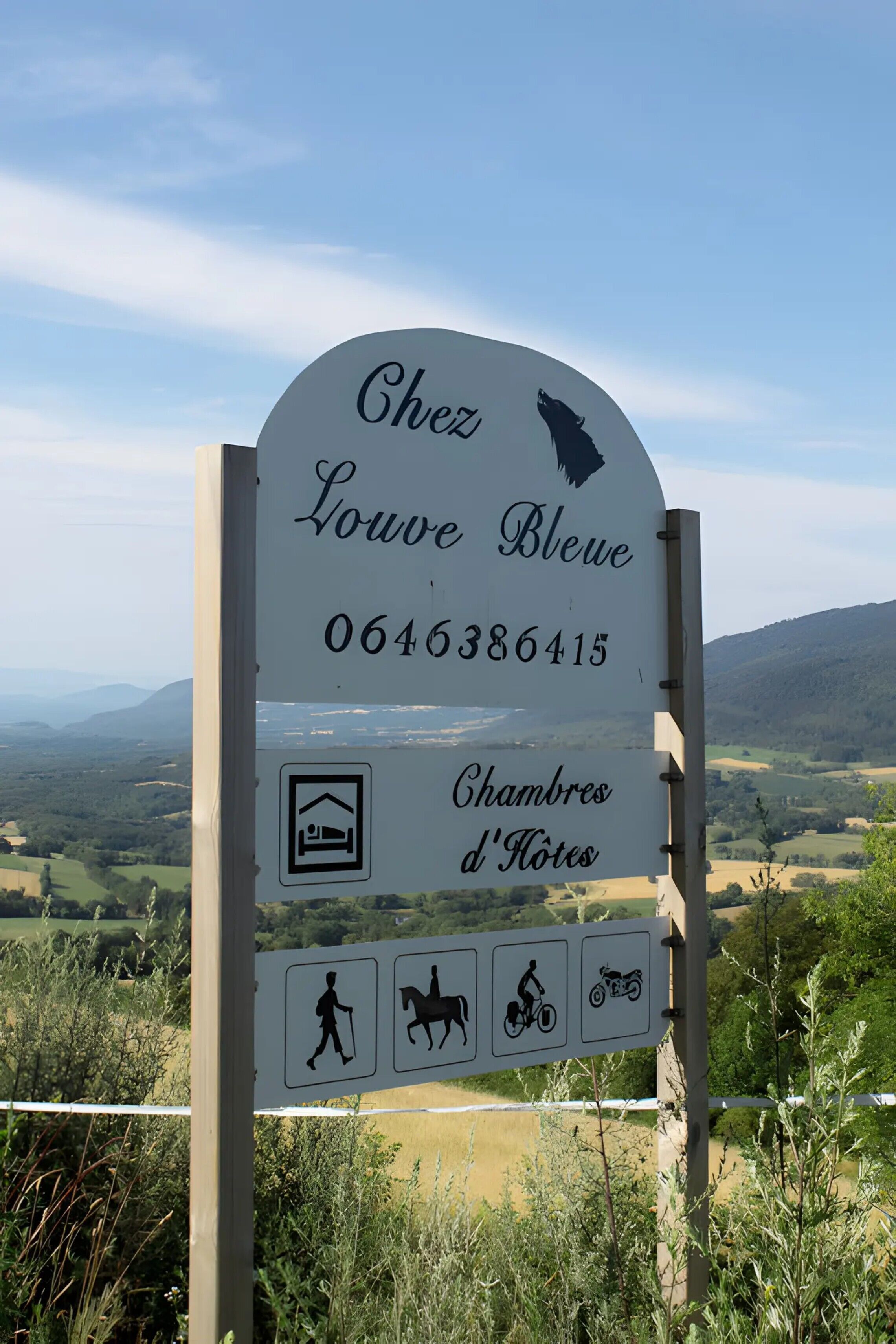 Een bord met de naam 'Chez Louve Bleue' en een telefoonnummer, dat een accommodatie aangeeft.