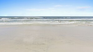 A beach with a clear sky and calm waves. - 🏖️Top Floor with Ocean Views | Awesome Amenities | Point East 320🏖️ (New Smyrna Beach)