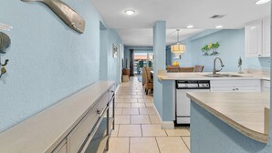 A kitchen with a light blue wall, a fish decoration, a dishwasher, and a counter. - 🏖️Top Floor with Ocean Views | Awesome Amenities | Point East 320🏖️ (New Smyrna Beach)