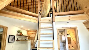 Un intérieur en bois avec un escalier central menant à un niveau supérieur.