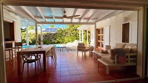 En rummelig terrasse med spiseplads, en pool og et loungeområde med sofa og bord.