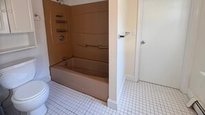 Un baño con inodoro, bañera y ducha.