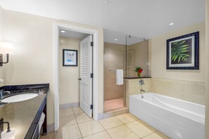 A modern bathroom with a sink, mirror, shower, and bathtub.