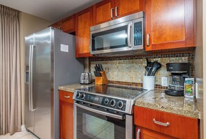 A kitchen with a stainless steel refrigerator, Bosch microwave, stove, and oven.