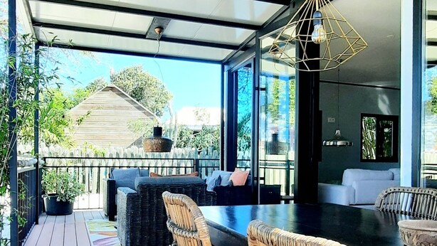 Un espace extérieur aménagé avec des meubles de jardin en osier, comprenant des chaises et une table, et offrant une vue sur un paysage pittoresque.
