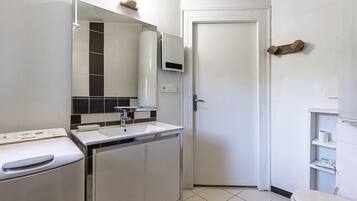 Une salle de bain moderne avec un lavabo blanc, un miroir et des toilettes.