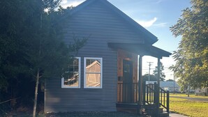 A small, single-story house with a front porch, a visible window, and a door. - Cozy Tiny House in Scottsburg (Scottsburg)