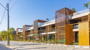 A modern building with multiple balconies and a wooden facade. - TMH - Essence Condominium in Porto de Pedras/al (Porto de Pedras)
