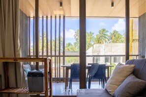 Une pièce moderne dotée d’une grande fenêtre, d’un canapé, d’une table et d’une chaise.