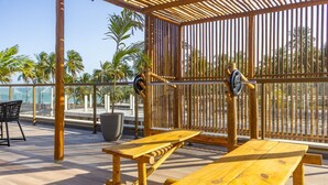 A wooden deck with a pergola, a bench, and a table. - TMH - Essence Condominium in Porto de Pedras/al (Porto de Pedras)