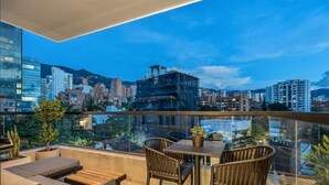 A rooftop terrace with a city view, outdoor seating, and potted plants. - City Lights in El Poblado 2 bedrooms, 2 Bathrooms, 2 Air Conditioners,2 Safes (Medellín)