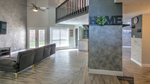 A spacious lobby with a long reception desk, a high ceiling with a fan, and a view of the outdoors through large windows. - Spacious Family-Friendly 3BR Home w/ Yard Near Richmond & Rosenberg (Richmond)