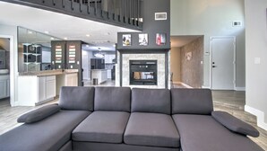 A modern living room with a sectional sofa, a fireplace, and a kitchen in the background. - Spacious Family-Friendly 3BR Home w/ Yard Near Richmond & Rosenberg (Richmond)