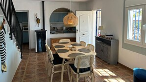 Un espace repas comprenant une table ronde, des chaises et un luminaire suspendu.