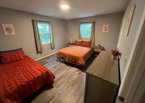 Une chambre avec deux lits, un bureau et une fenêtre.