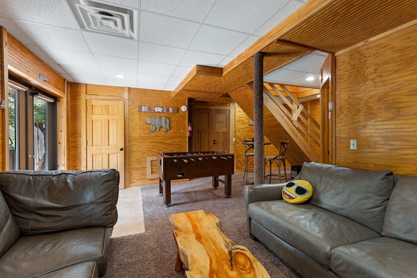 A cozy room with a foosball table, leather sofas, and a wooden coffee table. - Beartastic Outlook | Hocking Hills, Hot Tub (Rockbridge)