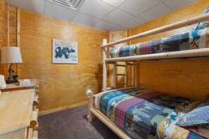 A bunk bed with a colorful quilt, a wooden desk with a lamp, and a motivational poster on the wall. - Beartastic Outlook | Hocking Hills, Hot Tub (Rockbridge)