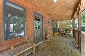 A wooden cabin with a porch, a welcome sign, and a bench. - Beartastic Outlook | Hocking Hills, Hot Tub (Rockbridge)