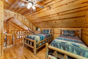 A cabin with two wooden beds, a staircase, and a ceiling fan. - Beartastic Outlook | Hocking Hills, Hot Tub (Rockbridge)