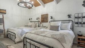 A bedroom with two beds, a wooden ceiling, a wall-mounted shelf, and a hanging light fixture. - Bright, beautiful condo in the heart of Mammoth, near shuttle, shops, ski & golf (Mammoth Lakes)