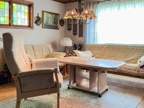 A cozy living room with a sofa, armchair, and a coffee table. - 4 Person Holiday Home in Smedstorp (Tomelilla)