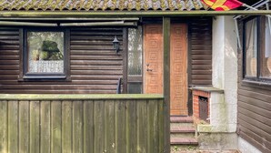 A wooden cabin with a tiled roof, a wooden door, and a small window. - 4 Person Holiday Home in Smedstorp (Tomelilla)