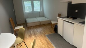 A compact living space with a kitchenette, a sofa bed, and a dining area. - Apartment 21 in Sollentuna Stockholm (Sollentuna)