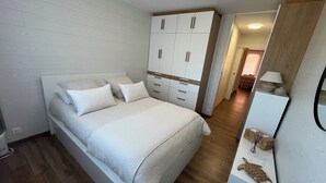 A bedroom with a bed, a wardrobe, and a mirror. - Lake - Golden Triangle (Annecy)