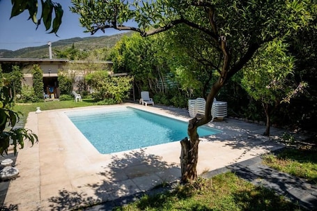 Una piscina al aire libre de temporada, sillones reclinables de piscina