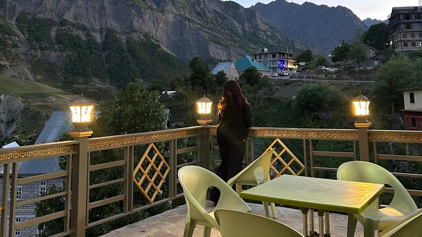 Una terraza con mesa y sillas, con vistas a un paisaje montañoso.