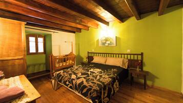 Una habitación con una cama de madera, una mesita de noche y una mesa con una lámpara.