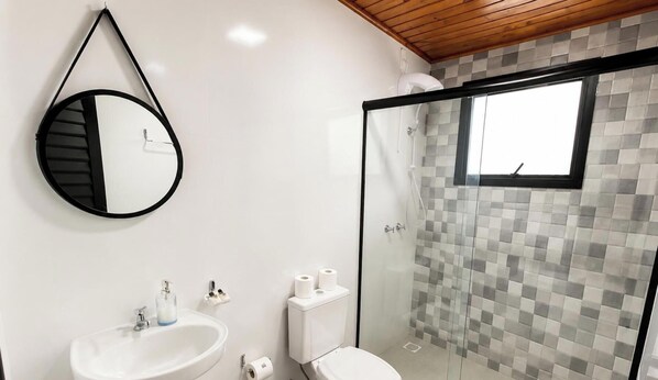 Ein Badezimmer mit Toilette, Waschbecken und Dusche.