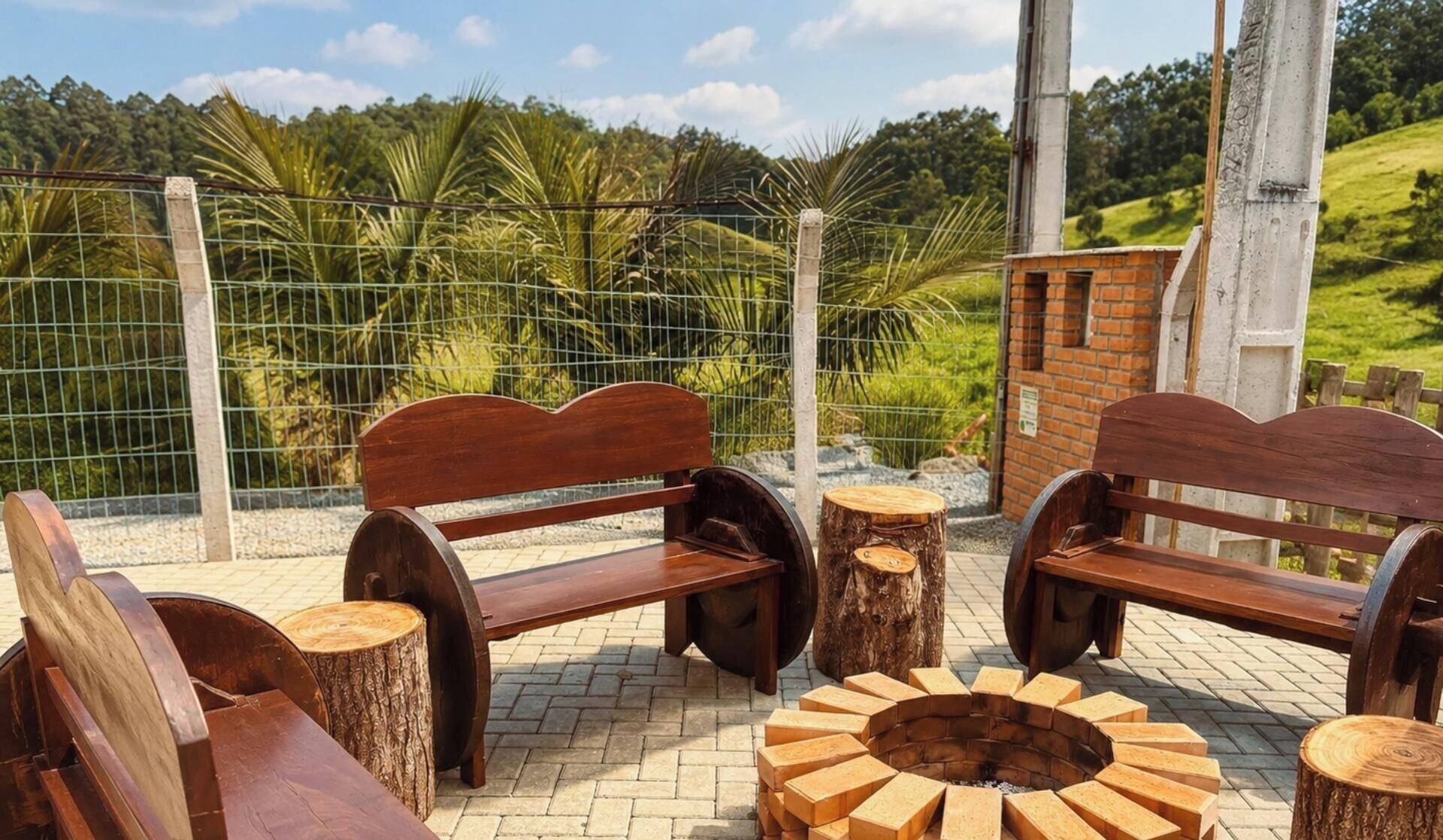 Outdoor seating with benches and a circular fire pit surrounded by wooden logs.