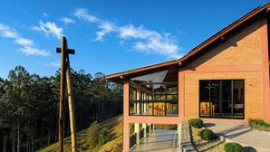 Un edificio moderno con fachada de vidrio amplia, una cruz de madera y exterior de ladrillo.