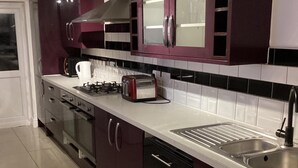 Una cocina moderna con electrodomésticos de acero inoxidable, una cocina a gas, un tostador y un lavamanos.