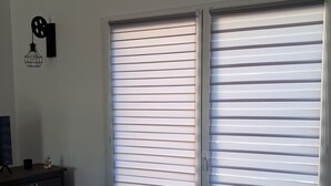 Ein Zimmer mit zwei großen Schiebetüren, einem kleinen Tisch mit Lampe und einer Wandleuchte.