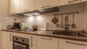 A modern kitchen with a stainless steel sink, a coffee maker, and a kettle on the countertop. - La casa del Vicolo: 2 camere letto, Wi-Fi & A/C (Modena)