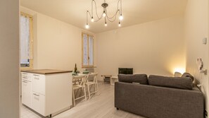 A compact living space with a kitchenette, dining area, and a sofa. - La casa del Vicolo: 2 camere letto, Wi-Fi & A/C (Modena)